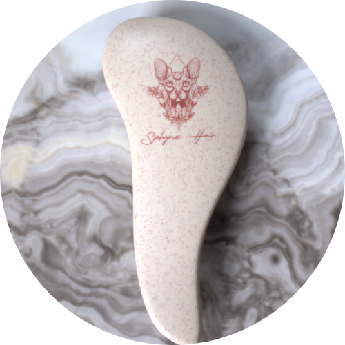 White hairbrush with red logo and text on a marble background