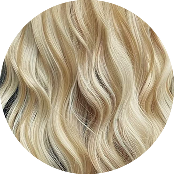 Close-up of wavy hair with blonde and brown tones on a white background